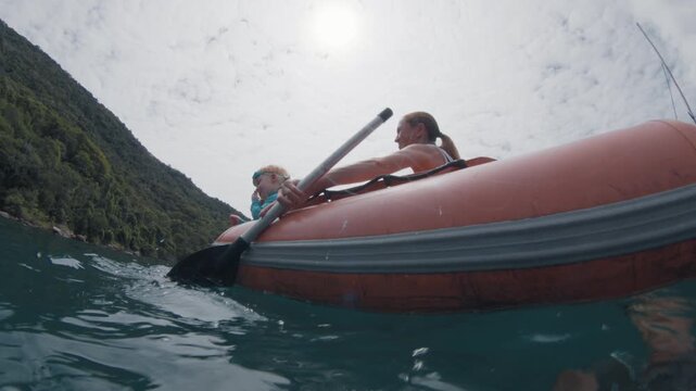 Splitted underwater view of the boat with family with kids on it