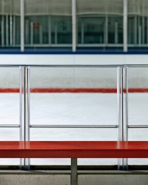 Ice hockey arena bench with scratched plexiglass boards and red railing for sports design poster background