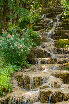 Water trickling over natural green mossy tufa rock cascades and travertine terraces at Bigar Waterfall near Kalna village at Stara Planina nature reserve in Serbia.