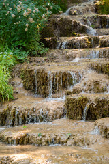 Water trickling over natural green mossy tufa rock cascades and travertine terraces at Bigar Waterfall near Kalna village at Stara Planina nature reserve in Serbia. © Dragan
