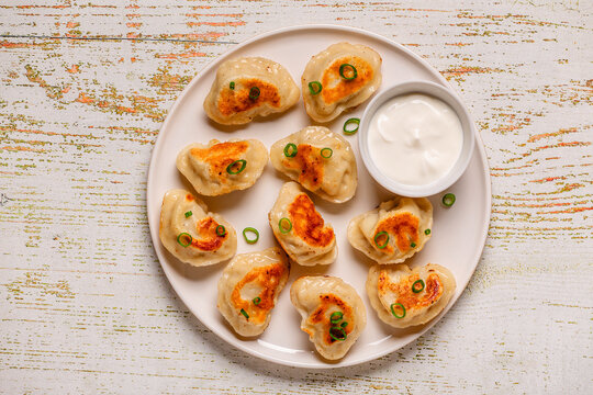 Fried dumplings on a white plate with sauce