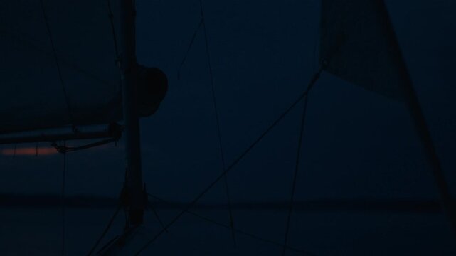 Lightning flashes in the night sky with sailing boat on the foreground