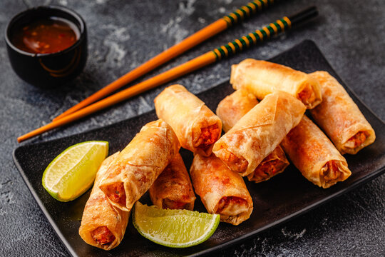 Fried spring rolls served with sauce and lime