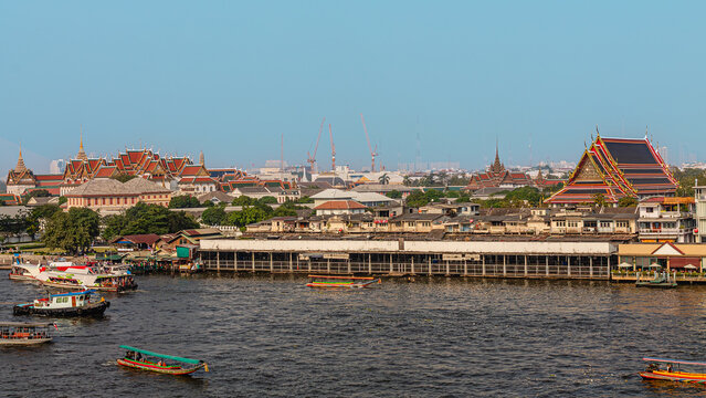Cityscape view of riverside temples and boats during daytime in Bangkok, Thailand