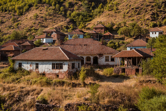 Traditional old houses made of mud, earth, and wood under a steep rocky hill in Topli Do village, showcasing authentic vernacular architecture at Stara Planina in Serbia 13.08.2026