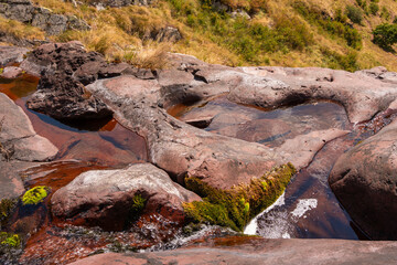 Close up view of fresh water trickling down red sandstone rocks at Razdoljski waterfall (Razdolje) near Kaludjerski Skok at Stara Planina nature reserve, Serbia. © Dragan