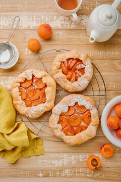 Top view of homemade apricot galettes dusted with powdered sugar on a