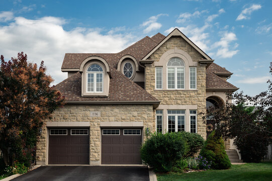 Large stone suburban house with two car garage