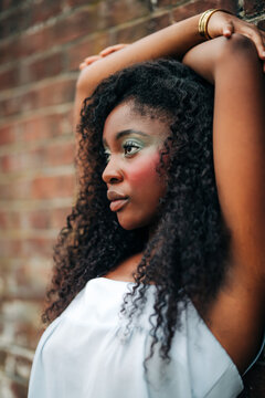 Beautiful black woman with colorful makeup poses outdoors