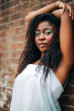 Confident young woman with bold makeup poses outdoors