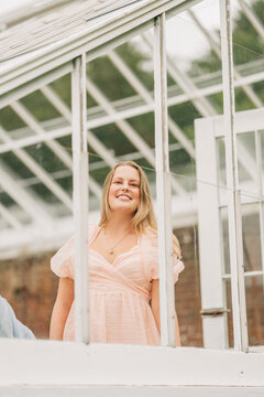 Happy woman looking up through a greenhouse window