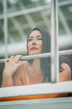 Thoughtful woman gazes out of a greenhouse window