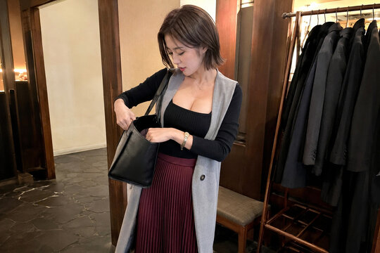 コート掛けのある店内でトートバッグを探す女性の外出準備