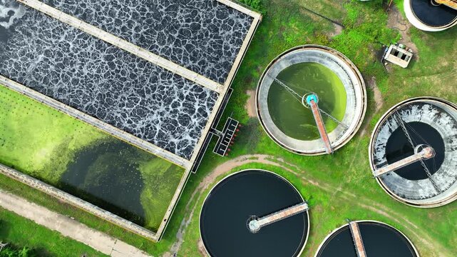 An industrial wastewater treatment plant with circular settling tanks and aeration basins, showing advanced water purification systems, pollution control, and sustainable industrial management. 4k.
