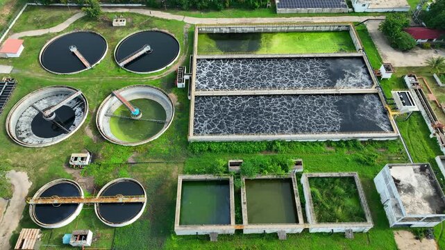 Drone view of an industrial water treatment facility featuring circular clarifiers and aeration basins, showcasing wastewater processing, ecosystem protection, and sustainable environmental solutions.