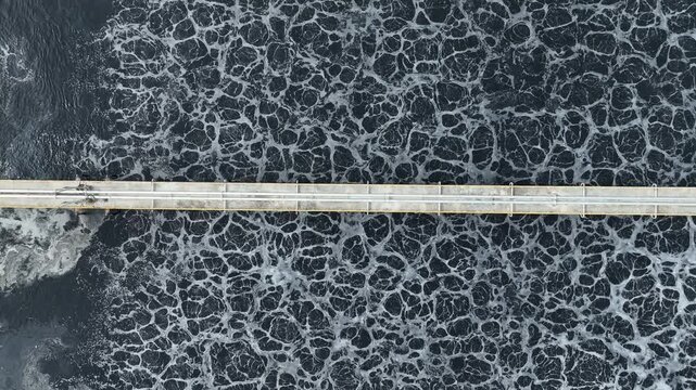 High angle aerial view of contaminated industrial wastewater with swirling foam textures, illustrating wastewater treatment systems, industrial pollution challenges, and environmental protection.