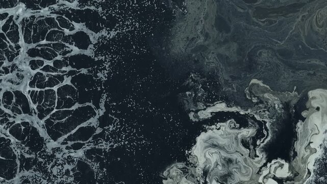 Drone view capturing black wastewater surfaces and oxygen bubbles in an industrial treatment facility, representing biological treatment, water recycling, and advanced waste management technology.
