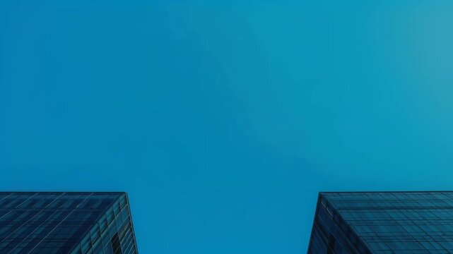 Blue Glass Skyscraper Building Facade Framing Clear Blue Sky with Dramatic Architecture Perspective