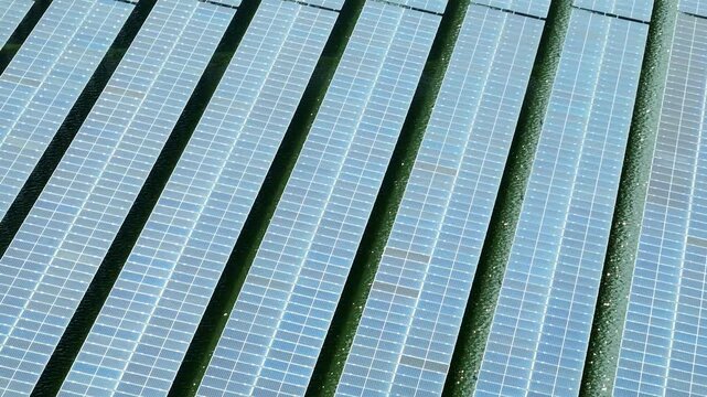 High angle aerial view of solar cell panels installed on a water facility, symbolizing renewable energy transition, climate action, resource efficiency, and sustainable future solutions.
