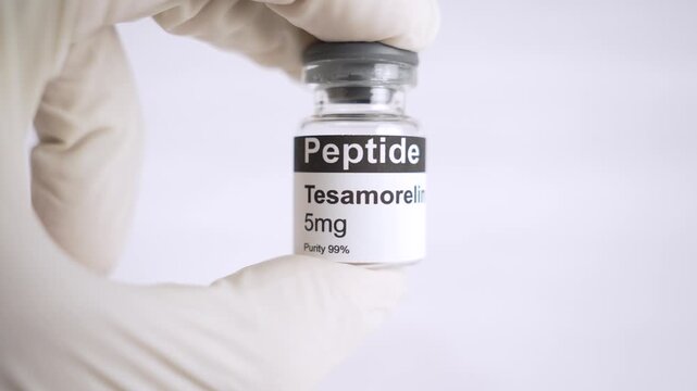 Gloved hand holding tesamorelin peptide vial