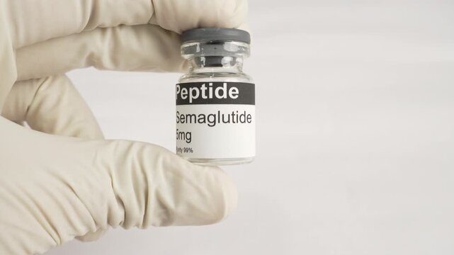 Gloved hand holding semaglutide peptide vial for diabetes