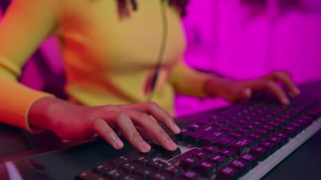 Close up of African American teenage girl playing online video game on computer. 