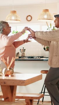 Dancing, happy and senior couple in kitchen at house listening to music, radio or song together. Smile, love and elderly man with woman moving to album for bonding, connection or marriage in home.