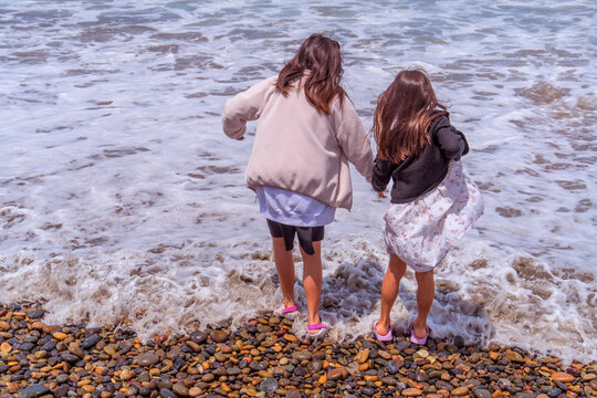 Summer Memories &ndash; Children Playing Together with Ocean Waves at the Beach
