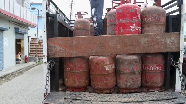 Indian Woman Handling LPG Gas Cylinders in Rural Village, featuring fuel, household, cooking, with the activity clearly visible in the rural setting and natural surroundings.
