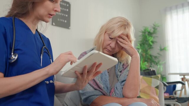 Caucasian caregiver assisting senior woman during health consultation. 