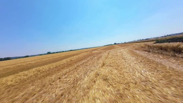 FPV drone fast low flight skim over rural farmland near high voltage power lines and pylons UK