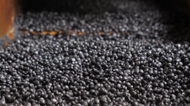 Recycled plastic granules moving on factory conveyor belt
