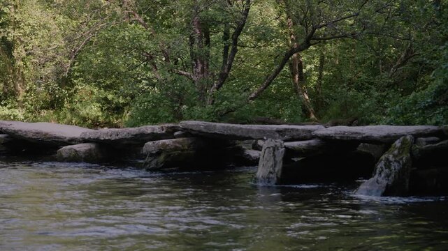 Tarr Steps during daylight capturing the historic clapper bridge and its natural surroundings. The clear water, peaceful woodland setting create a timeless and atmospheric scene in the heart of Exmoor