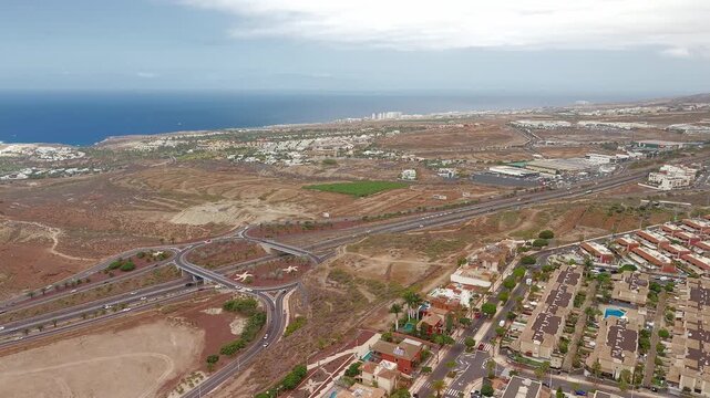 Aerial view of Adeje showing dry landscape, highways, and coastline in Tenerife