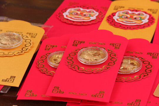 Traditional Vietnamese red and gold envelopes with commemorative gold foil coins for the 2026 Lunar New Year of the Horse.
