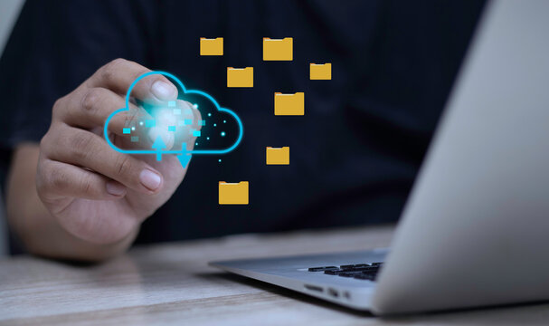 Cloud storage backup, document folder transfer, and file management concept with businessman touching glowing cloud icon near floating folders and laptop.