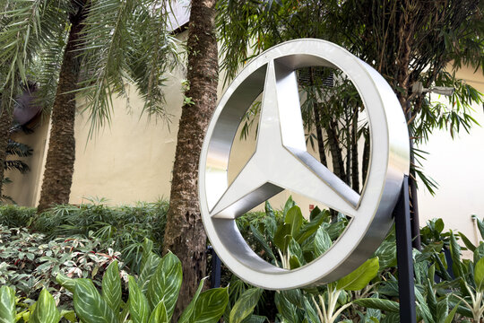 PENANG, Malaysia - Apr 05, 2026: Mercedes Benz logo displayed among tropical greenery at an automotive showroom in Malaysia.
