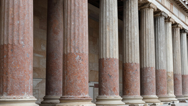 Rows of fluted Greek and Roman marble pillars along a classical architectural colonnade