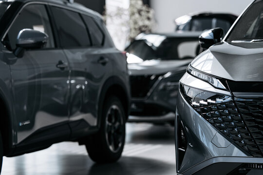 New car displayed in a dealership with emphasis on modern front lighting and grille design.