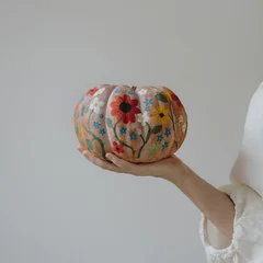 Woman Holding Hand Painted Pumpkin Decorated With Colorful Floral Patterns © Floral Deco