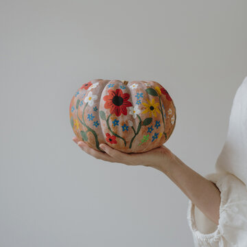 Woman Holding Hand Painted Pumpkin Decorated With Colorful Floral Patterns