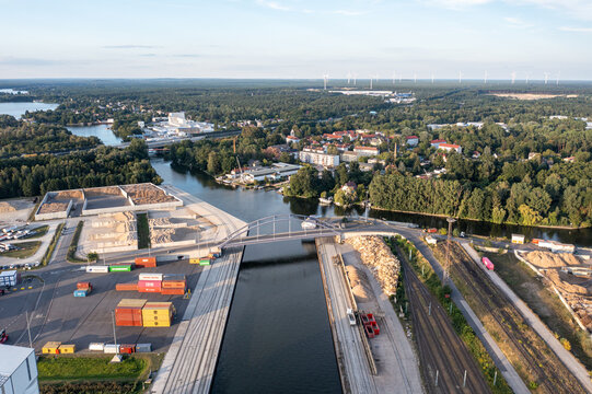 Aerial view of Container Terminal METRANS with colorful shipping containers, a bridge over the canal, railway tracks, and surrounding industrial landscape in Wildau, Brandenburg, Germany.