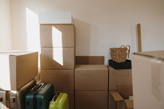 Stacked Cardboard Storage Boxes With Handwritten Labels In New Apartment Interior