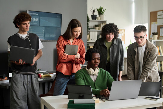 Diverse group of university students studying together with laptop