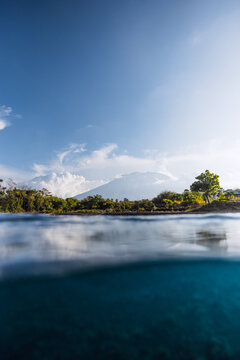 Blue ocean and volcano mountain in Bali. Split view of blue sea waters surface