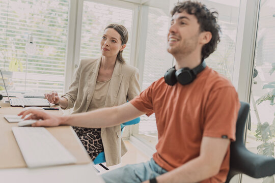 Man and woman watch a presentation in the office