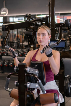 Woman performs upper body workout on a gym machine