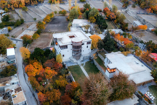 Aerial view of Serena Khaplu Palace surrounded by vibrant autumn foliage, historic stone walls, and terraced gardens in Khaplu, Pakistan.