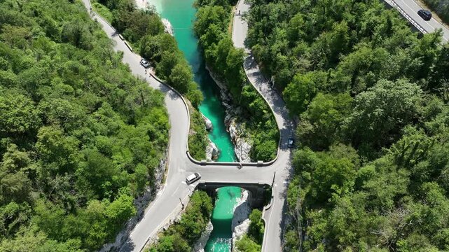Aerial top down perspective captures turquoise Soca river crystal clear water. rocky canyon banks surrounded by dense wild green forest near Kobarid.