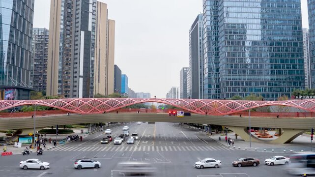 Modern city intersection with pink pedestrian bridge and high rise buildings
